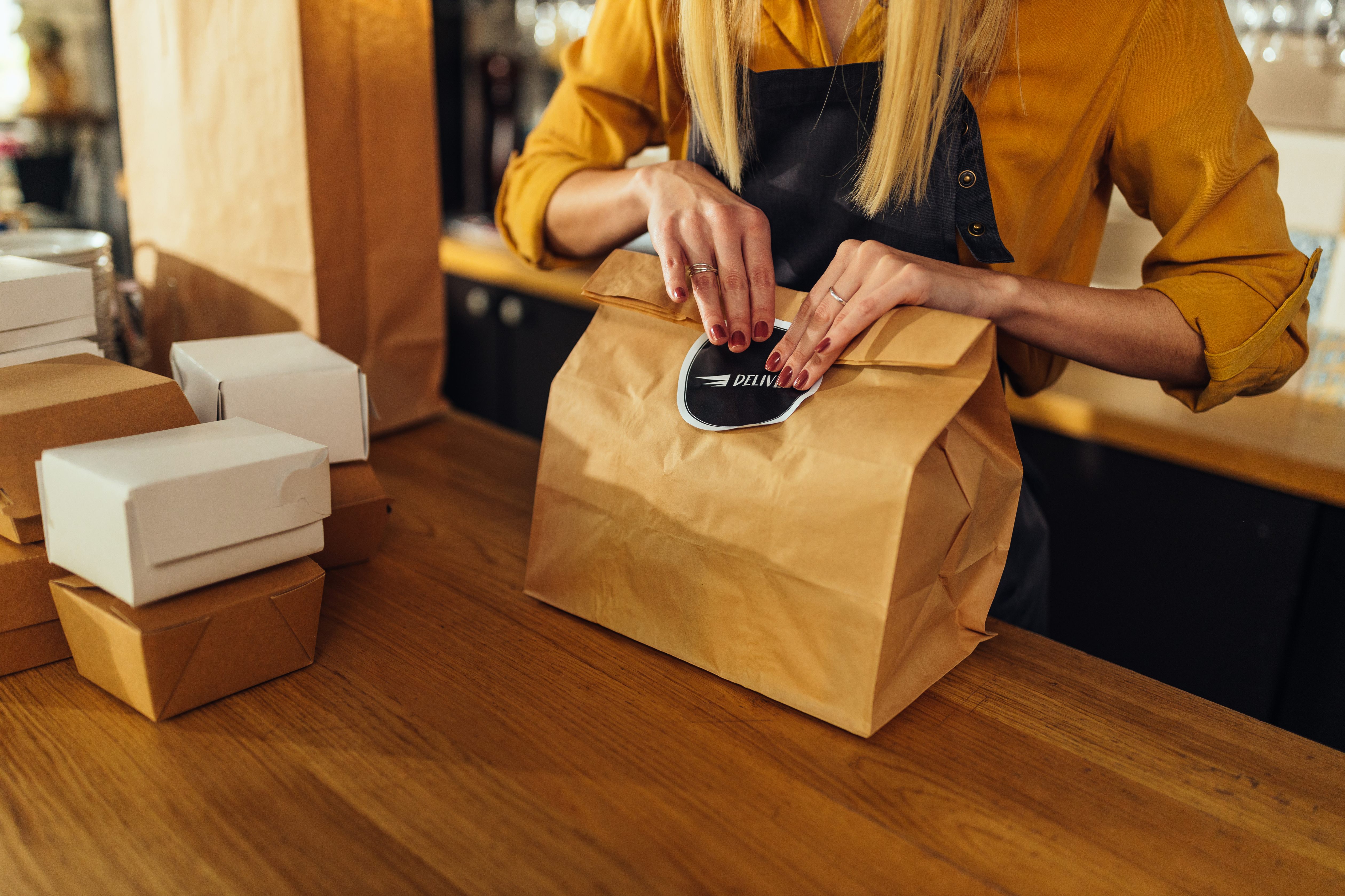 Close up of woman packing food for delivery